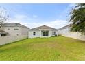 Spacious backyard with lush green grass enclosed by a white fence, offering plenty of room for outdoor activities at 1504 Finchburg St, Minneola, FL 34715