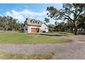 House showcasing a side view with attached garage and large oak tree at 2850 Horton Rd, Kissimmee, FL 34744