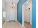 Bright entryway with tile flooring, a chandelier, and blue accent wall at 306 Quarry Rock Cir, Kissimmee, FL 34758