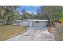 Newly renovated house with gray exterior, landscaping, and driveway at 32650 Azealia Pl, Tavares, FL 32778