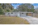Newly renovated house with gray exterior, landscaping, and driveway at 32650 Azealia Pl, Tavares, FL 32778