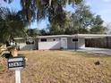 Gray house with carport, landscaping, and a spacious yard at 32650 Azealia Pl, Tavares, FL 32778