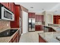 Spacious kitchen with dark wood cabinets and granite countertops at 3915 Shoreview Dr, Kissimmee, FL 34744