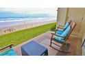 Relaxing oceanfront patio with rocking chairs, offering stunning beach views at 4153 S Atlantic Ave # 1020, New Smyrna Beach, FL 32169