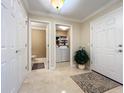 Bright foyer with tile floor, front door, plant, and entryways to a laundry room and a powder room at 4208 Clubside Dr # 4208, Longwood, FL 32779