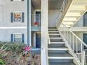 Exterior view of a condo building's stairwell and doors with shutters and landscaping at 4208 Clubside Dr # 4208, Longwood, FL 32779