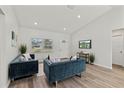 Open living area with teal sofas, wood-look floors, and a large TV at 4386 Sw 169Th Lane Rd, Ocala, FL 34473