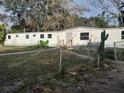 Single-wide mobile home with a chain link fence and a cactus at 5149 Bryant Ave, Sanford, FL 32773