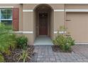 Front entry with a paved walkway, landscaping, and a brown door at 603 Lazio Cir, Debary, FL 32713