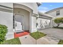 White front door with a red welcome mat and landscaping at 10828 Cherry Oak Cir, Orlando, FL 32817