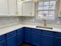 Modern kitchen with blue cabinets, white countertops and geometric backsplash at 118 Mandrake St, Orlando, FL 32811