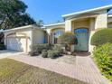 House exterior with a green door, brick walkway, and neatly trimmed shrubs at 140 Rangeline Woods Cv, Longwood, FL 32750