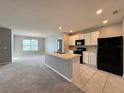 Modern kitchen with white cabinets, black appliances, and an island at 193 Grove Branch Rd, Winter Haven, FL 33880