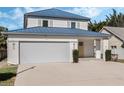 Two-story house with a blue metal roof and attached garage at 1975 Biscayne Dr, Winter Park, FL 32789