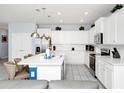 Modern kitchen with white cabinets, a large island, and stainless steel appliances at 1986 Summer Dr, Davenport, FL 33897