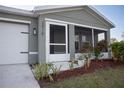 Front entrance with a screened porch and well-maintained landscaping at 2016 West Pkwy, Deland, FL 32724