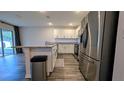 Bright kitchen with stainless steel refrigerator, granite countertops, and modern appliances at 2016 West Pkwy, Deland, FL 32724