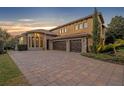 Three-car garage with paver driveway and stone accents at 2185 Talman Court, Winter Park, FL 32792