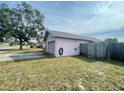 Side yard view showcasing a pink house with an attached garage at 282 W Summit St, Apopka, FL 32712