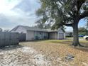 Landscaped yard with a large tree and a pink house with attached garage at 282 W Summit St, Apopka, FL 32712