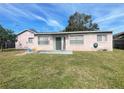 Back exterior of the house with a patio and grassy backyard at 282 W Summit St, Apopka, FL 32712