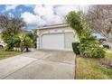 Tan house with white garage door, landscaping, and driveway at 3264 River Branch Cir, Kissimmee, FL 34741