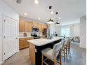 Modern kitchen with an island, stainless steel appliances, and light wood cabinets at 429 Tisone Ln, Davenport, FL 33837