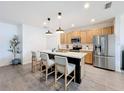 Modern kitchen with island, stainless steel appliances, and light wood cabinets at 429 Tisone Ln, Davenport, FL 33837