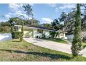 House exterior view, light green painted walls, driveway and landscaped lawn at 109 Wynot Way, Deland, FL 32724