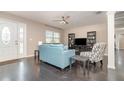 Living room with dark hardwood floors, blue sofa, and a large TV at 109 Wynot Way, Deland, FL 32724