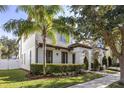 Two-story house with white siding, palm trees, and manicured hedges at 11560 Ashlin Park Blvd, Windermere, FL 34786