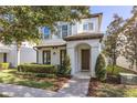 Two-story house with white siding, a charming porch, and neatly landscaped yard at 11560 Ashlin Park Blvd, Windermere, FL 34786