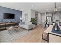 Open living space with light wood floors, a neutral color palette, and a stylish TV wall at 12455 Shipwatch St, Orlando, FL 32832