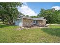 Single story home with stone exterior, and lush green lawn at 1365 Indian Rock Ct, Deltona, FL 32725