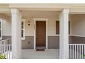 Inviting front porch with decorative columns and neutral tones, creating a warm entry at 13731 Bravante Aly, Windermere, FL 34786