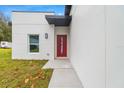 Red front door and walkway leading to modern house at 3065 Jon Jon Ct, Orlando, FL 32822