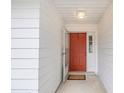 Front entry with coral door, welcome mat and white walls at 5132 Lazy Oaks Dr # 5132, Winter Park, FL 32792