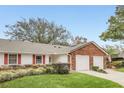 Exterior view of a two-unit home with a double garage and well-maintained landscaping at 5132 Lazy Oaks Dr # 5132, Winter Park, FL 32792