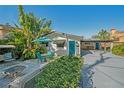 Charming home featuring a blue door, tropical landscaping, and a cozy outdoor seating area at 528 Broadway Ave, Orlando, FL 32803