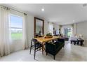 Dining area with wood table, green bench, and view into living room at 6022 Galloping Dr, Apopka, FL 32712