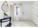 Bright entryway with tile floor, round mirror, and console table at 6022 Galloping Dr, Apopka, FL 32712