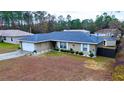 One-story house with a blue roof, attached garage, and a small yard at 6928 Sw 152Nd St, Ocala, FL 34473