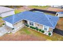 Single-story house, blue roof, white garage door, fenced backyard, and a shed at 6928 Sw 152Nd St, Ocala, FL 34473