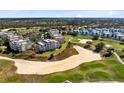 Aerial view showcasing a condo complex near a golf course, offering scenic views and recreational opportunities at 7618 Sandy Ridge Dr # 103, Reunion, FL 34747