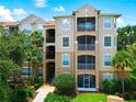 Three-story condo building with balconies and landscaping at 7654 Comrow St # 101, Kissimmee, FL 34747