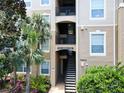 Exterior view of condo building with stairs and landscaping at 7664 Comrow St # 301, Kissimmee, FL 34747