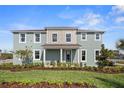 Two-story light blue home with landscaping and front porch at 12439 Shipwatch St, Orlando, FL 32832