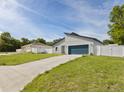 Modern home featuring a gray exterior, a blue garage door, and a well-manicured lawn and concrete driveway at 15033 Sw 35Th Cir, Ocala, FL 34473
