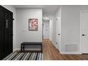 Bright entryway with black door, wood floors, and a bench at 200 Florida Ave, Geneva, FL 32732