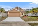 Tan two-story house with a red door, two palm trees, and a driveway at 2267 Santa Lucia St, Kissimmee, FL 34743